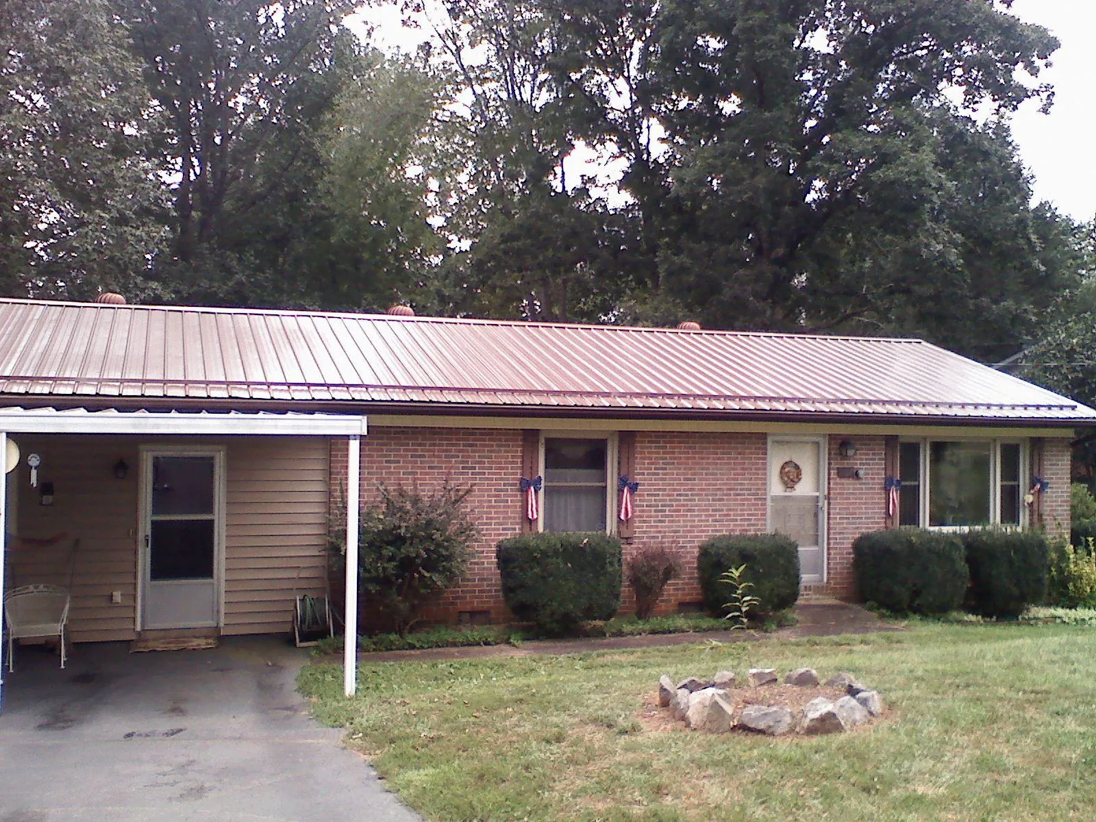 Bronze metal roof and carport on a brick ranch home — Roof Repair work by our crew in Paradise